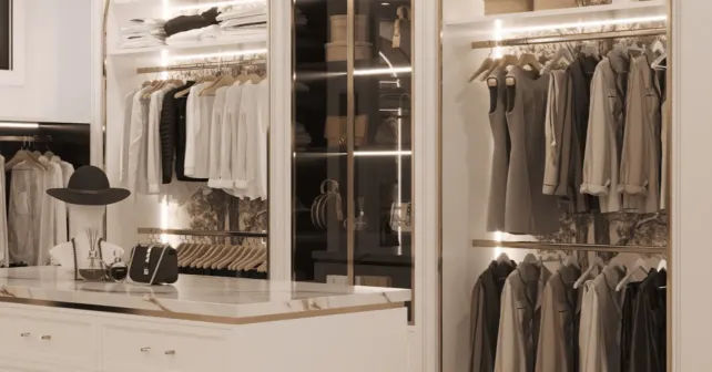Stylish walk-in closet with illuminated clothing racks and accessories.