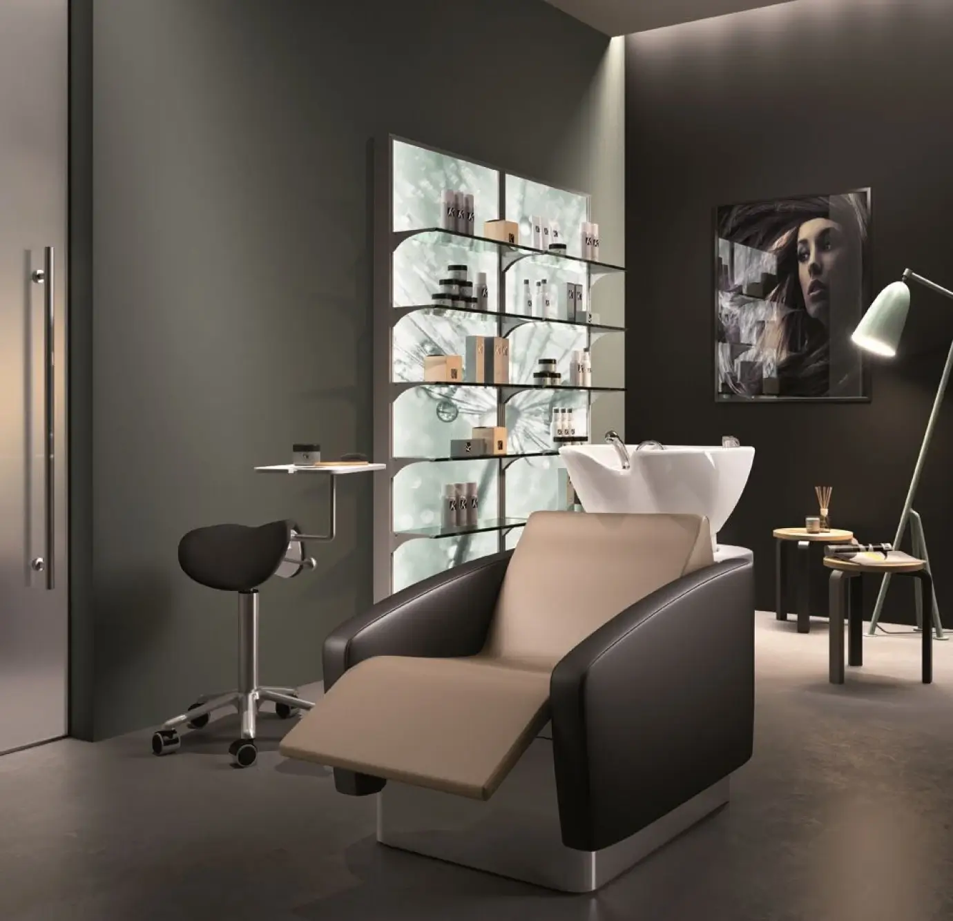 Luxury hair salon single shampoo station featuring a black and tan leather reclining wash chair, white ceramic bowl, backlit glass product display wall, and editorial hair art print